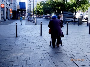Rollaattori ja vanhempi nainen kävelykepin kanssa ulkona