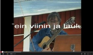 Olli Orrenmaa viinilasin ja mikrofonin kanssa