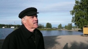 Pertti Salo hymyilee ja osoittaa kohti Mansikkasaaren tanssilavaa