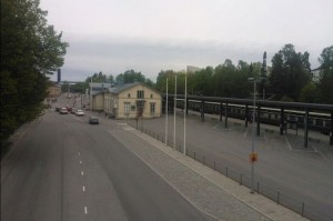 Juna saapuu asemalle, matkustajat odottavat laiturilla