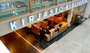 Kirjaston hyllyjä ja itsepalvelunoutopiste