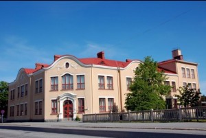 Palosaaren koulu, vaalea tiilirakennus ja sen piha