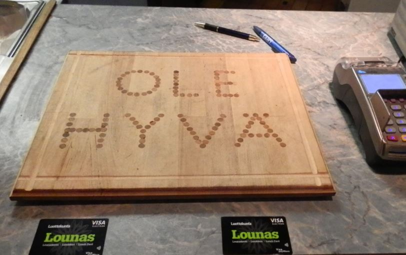 Asiakaspalvelija ojentaa palkintoa hymyillen