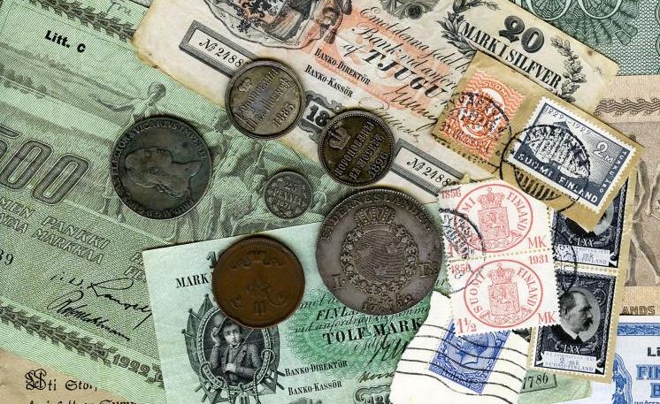 Vanhoja rahoja ja postimerkkejä pöydällä