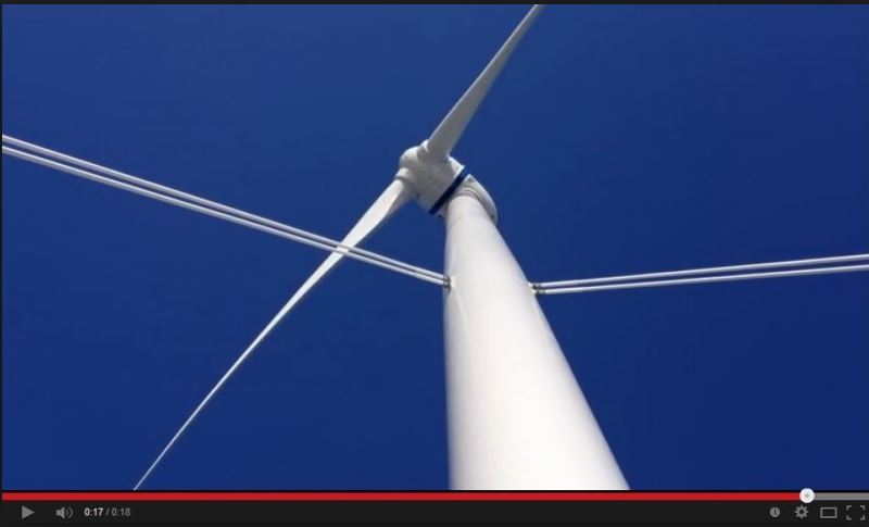 Tuulivoimala pyörivine lapoineen kohoaa pellon yllä