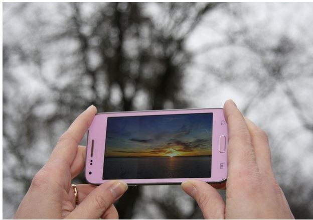 Nuori nainen hymyilee ja katsoo kameraan kesäisessä Vaasassa