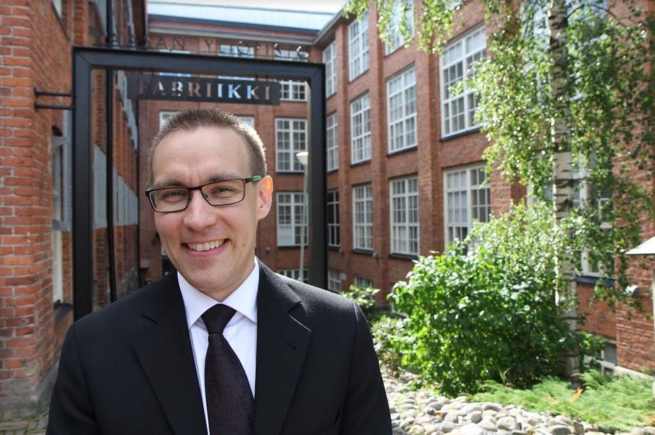 Ari Sivula hymyilee kameralle, taustalla toimistoympäristö