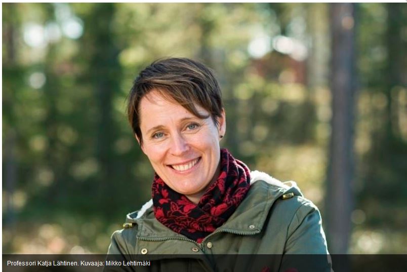 Katja Lähtinen hymyilee puurakenteisen talon edessä