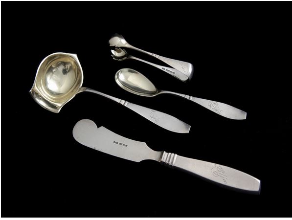 Hopeaesineitä, kuten lusikoita ja haarukoita, pöydällä