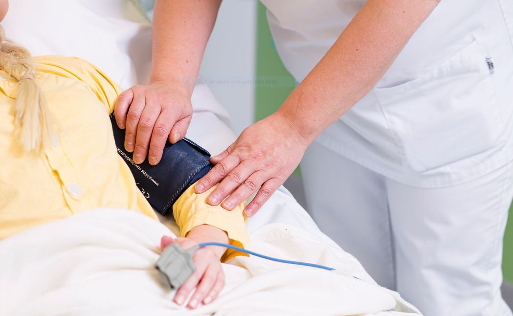 Kädet täyttävät vaaratapahtumailmoituslomaketta, kynä ja paperi