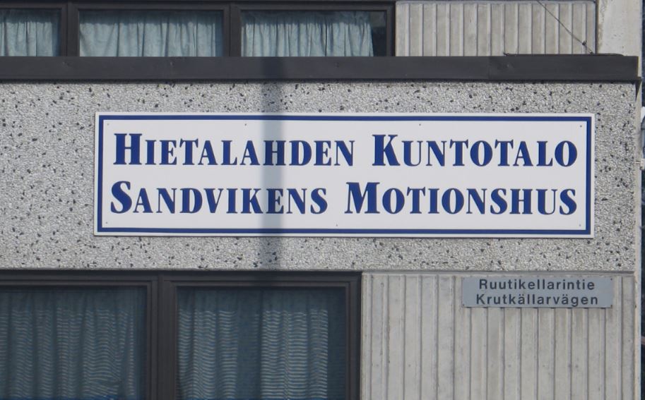 Hietalahden kuntotalon julkisivu, jossa on suuria ikkunoita ja tiiliseiniä