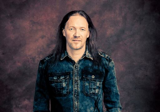 Nightwishin Kai Hahto hymyilee lavalla rumpujen takana