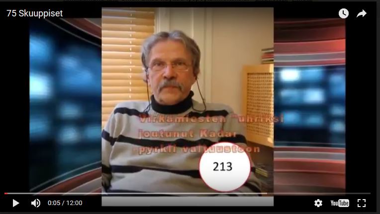 Juri Kadar puhuu vaalivideolla, taustalla Suomen lippu