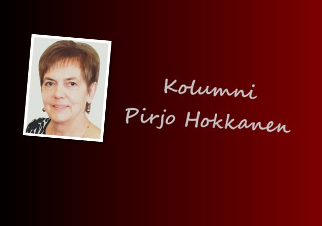 Pirjo Hokkanen hymyilee, taustalla Vaasan kaupungin logo