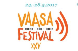 Vaasan kuorofestivaalin esiintyjiä lavalla, yleisöä katsomossa