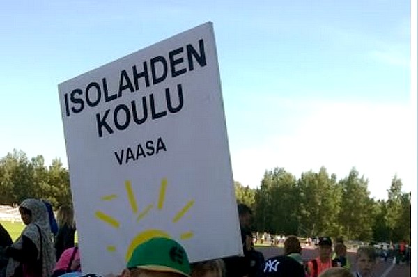 Isolahden koulun oppilaat tanssivat modernin koulurakennuksen edustalla