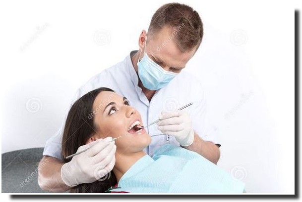 Hammaslääkäri ja potilas hymyilevät hammashoitolassa