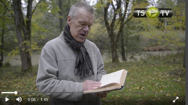 Risto Rasa hymyilee kameralle, taustalla kirjahyllyjä