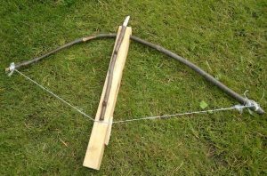 Jousipyssy ja nuolia, taustalla puinen seinä