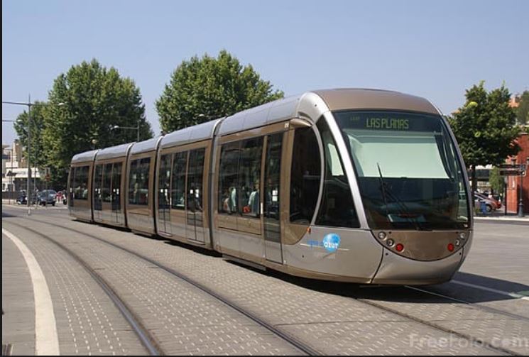 Raitiovaunu kulkee kaupungin kadulla, taustalla rakennuksia