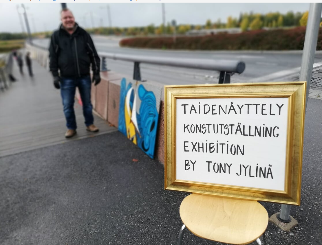 Tony Jylinä ripustaa taidetta Vaskiluodon sillan kupeeseen