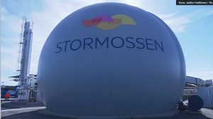 Stormossenin jätevoimala auringonlaskussa, savupiipusta nousee höyryä