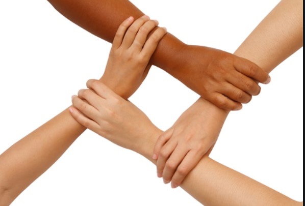 Käsi maalaa graffitia "Väestönvaihto" tiiliseinään